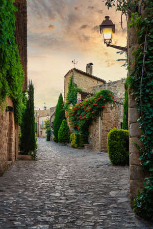 View of a flowered street in the medieval village of Peratallada, in Girona, Catalonia, Spain.のeditorial素材