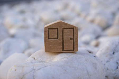 wooden house symbol place on rock backgroundの写真素材