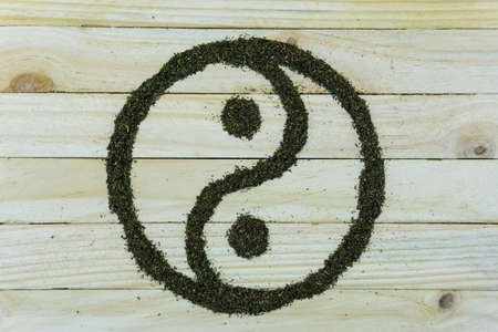 yin and yang symbol make by tea leaf on wooden backgroundの写真素材