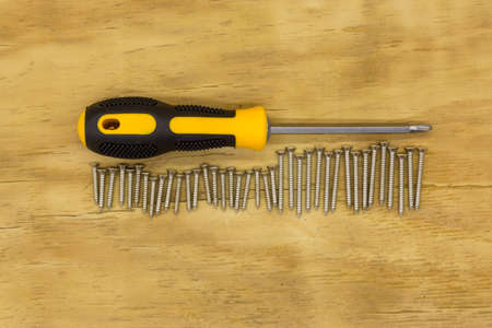 top view of screw driver and screw on wood backgroundの写真素材