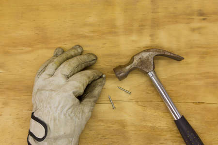 top view gloves with hammer on wooden backgroundの写真素材