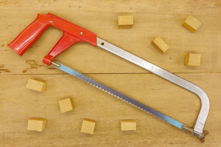 cutting wood with hand saw on wooden backgroundの写真素材