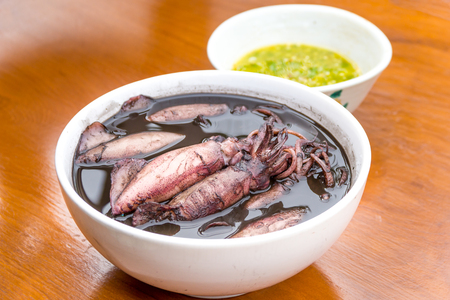 black squid boiled with seafood sauces on the wood table.の写真素材
