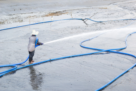 workers use high pressure water cleaning shrimp pondの写真素材