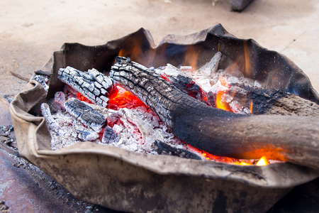 Wood charcoal fire on the old basin , villager kindling to relieve cold weather.の写真素材