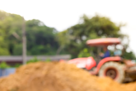 blurred of a tractor with driver plow the soil on the landの写真素材