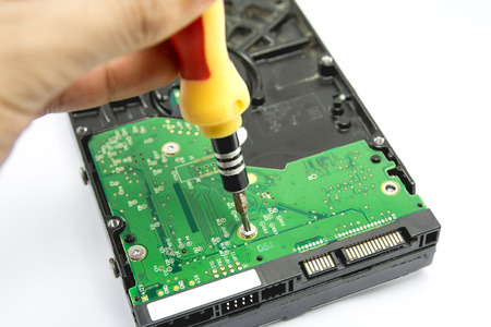 unscrew the scheme from the hard drive with a screwdriverの写真素材