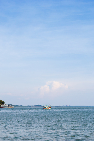 sky and sea with fisherman boat are driving out from the land , with space for textの写真素材