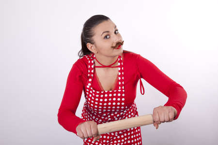 Young attractive housewife with rolling pin and moustaches.の写真素材