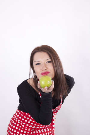 Young beautiful housewife holding green apple.の写真素材