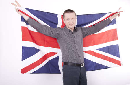Man holding flag of Great Britain with both hands and showing victory sign.