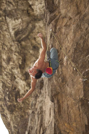 Young climber hanging of the cliff.