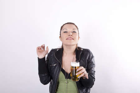 Young beautiful woman with a glass of beer and beer foam on her nose.の写真素材