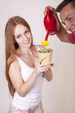 Portrait of a young happy couple watering flower.の写真素材
