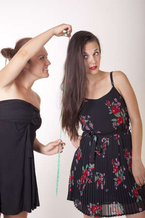 Portrait of two attractive women with measuring tape.の写真素材