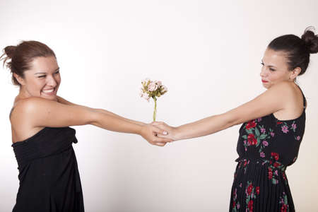 Portrait of a two beautiful sexy women sharing bouquet of flowers.の写真素材