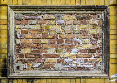 Old brick wall pattern closeup with stucco frame の写真素材