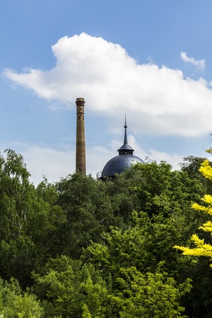vintage chimney and water tank behind a forest.の写真素材