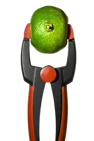 clamp is squeezing a lime, isolated on white の写真素材