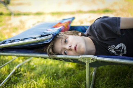 dreaming teen boy laying on a sunlounger.の写真素材