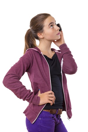 teenage girl speaking on mobile phone, looking into the sky, isolated on white.の写真素材