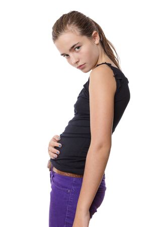 teenage girl holding here belly, isolated on white.の写真素材