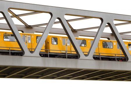 yellow moving train on an iron bridge with blue sky, isolated on white.