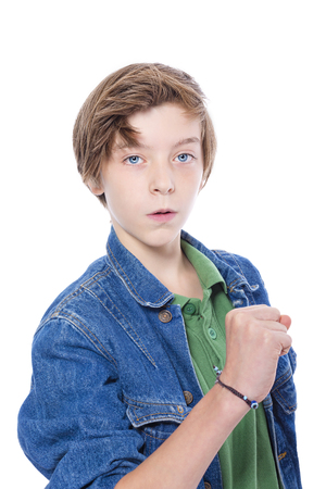 confident teenage boy showing his fist, isolated on white.の写真素材