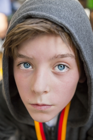 portrait of a teenage boy with grey hoodie sweatshirts, after sports with red face.の写真素材