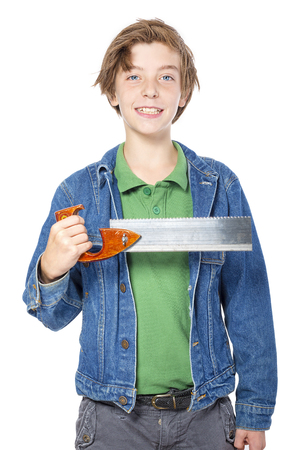 confident teenage boy holding a saw in one hand, isolated on white.の写真素材