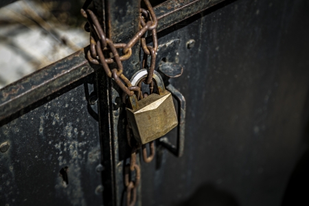 rusty chain on a metal door with  padlock.の写真素材