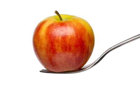 an red apple on a fork, isolated on white.の写真素材