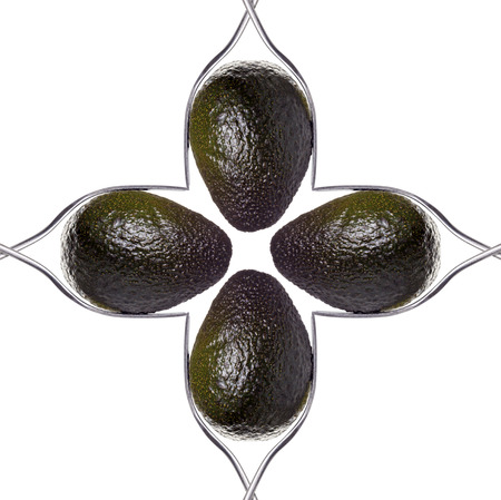 square of four avocados between two forks, isolated on white.の写真素材