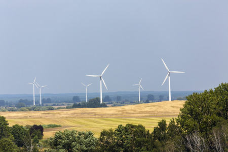 landscape with wind turbines forest and fields.