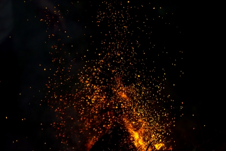 blurred background of a campfire with shower of sparks.