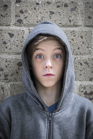 portrait of a male teenager with wide eyed in front of a wall.の写真素材