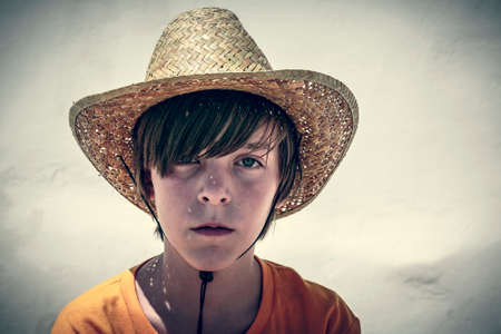 portrait of a male teenager with straw hat, vintage color filer.の写真素材