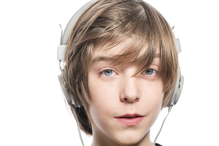 smiling cute teenager boy with headphones, isolated on white.の写真素材