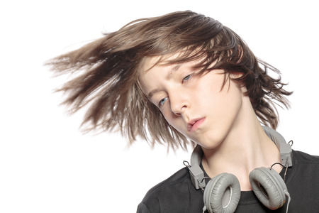 moving cool teenager boy with headphones, isolated on white.の写真素材