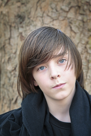 outdoor portrait of a male teenager in front of a tree.の写真素材