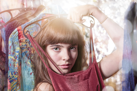beautiful teenage girl try a dress, with bokeh, backlit and light leakの写真素材