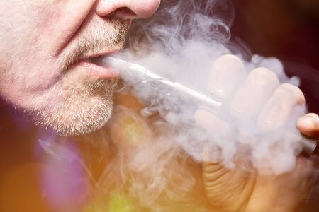 close up portrait of a man smoking an ecigarette