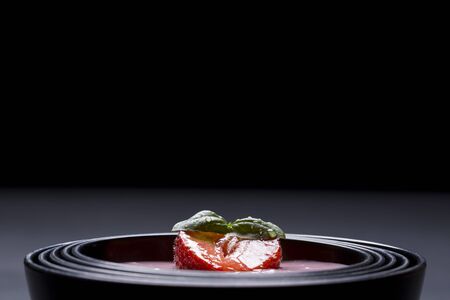 quark with strawberry in a black asian bowlの写真素材
