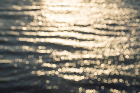 blurred ocean background with reflections and bokehの写真素材