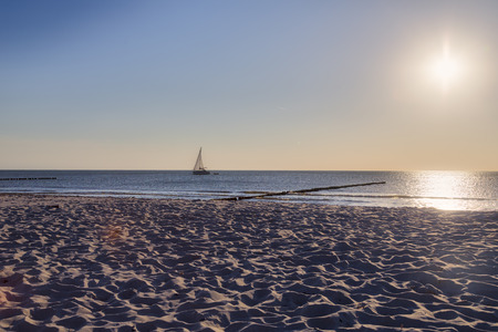 ocean landscape with sailing boat and sunの写真素材