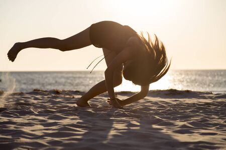 sunset and silhouette of a teenage girl in motion