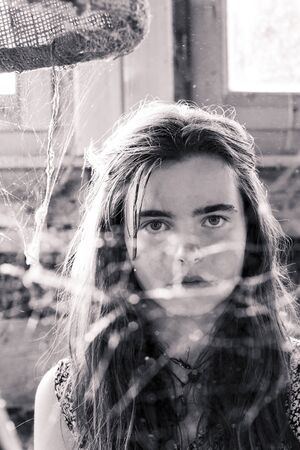 vintage shot of a teenage girl behind a spider web