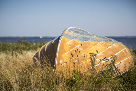 old boat laying in the grass at the seaの写真素材