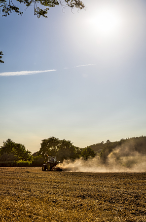 landscape with tractor plowing a fieldの写真素材