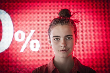 portrait of a smiling teenage girl in front of a digital screen